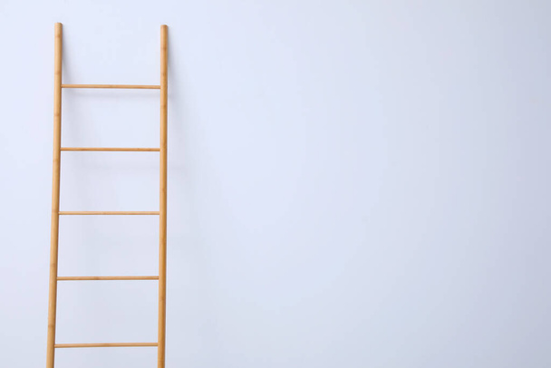 Modern wooden ladder on white background. Space for text - Foto, Imagen