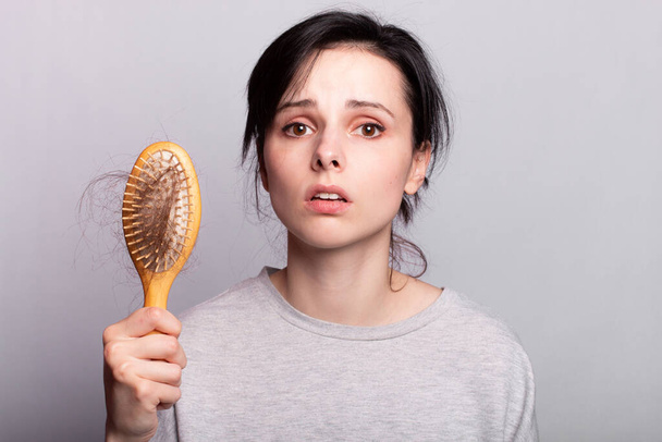 Beautiful woman comb hair grey shirt fall out - Photo, Image