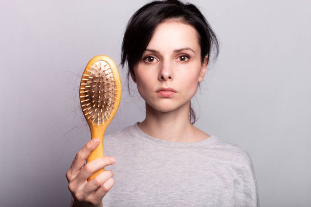 Woman with comb in hands problem hair - Foto, Imagem