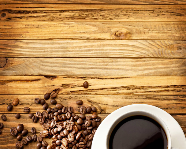 Šálek kávy a fazole na holém dřevěném povrchu - Fotografie, Obrázek