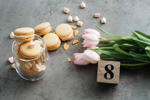 Friss tulipánok, sárga francia makarónok lapos háttere és a táblázat "Nyolc" megjegyzése - Fotó, kép