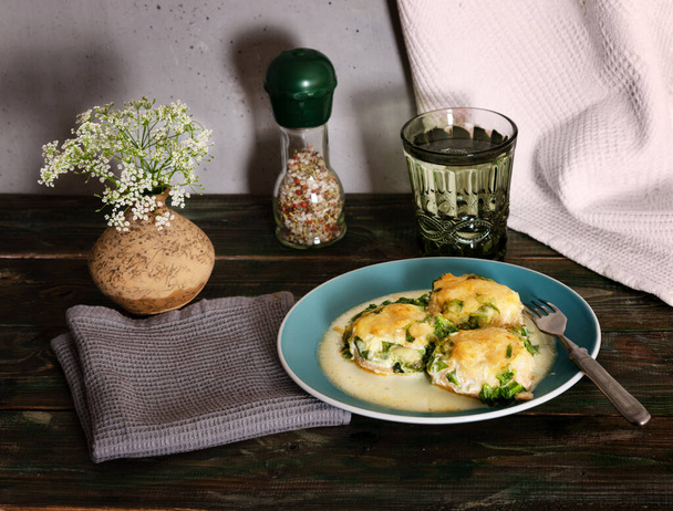 baked meatballs in spinach sauce with cheese on an old rustic wooden table - Foto, Bild