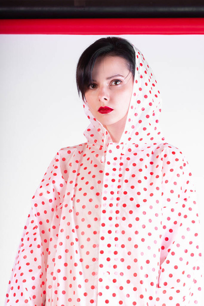 fashionable girl with red lips in a raincoat - 写真・画像