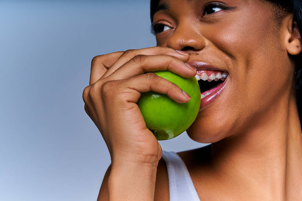 Nice female face with fresh juicy apple at the mouth - Фото, изображение