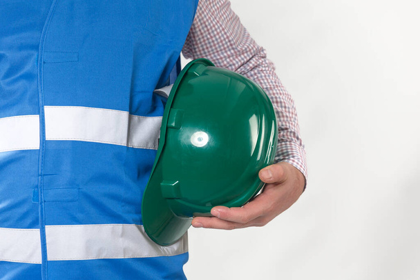 エンジニアリング管理建設エンジニアは現場の警備員の手に安全ヘルメットを持っています。ビジネスの概念です。コピースペース付きグレーの背景にヘルメットを保持する建設労働者 - 写真・画像