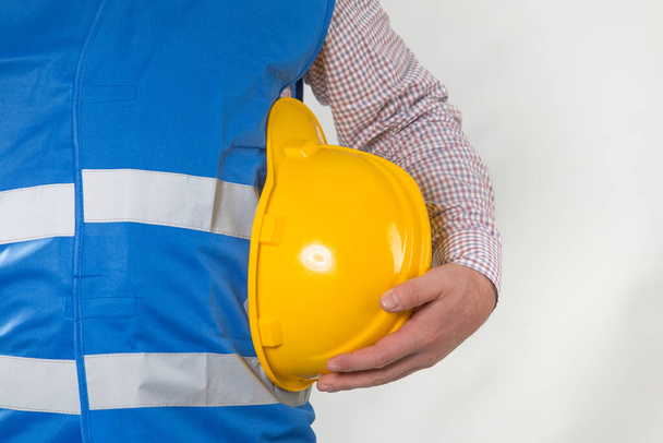 engineering management construction ,engineer hold in hand safety helmet for workers security on working site background. busines concept. construction worker holding helmet on gray background with copy space - Photo, Image