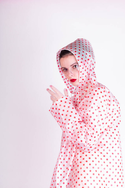 woman in a raincoat with red polka dots, transparent glasses - Foto, immagini