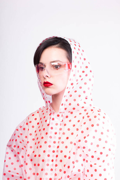 beautiful woman with red lips in a raincoat  - Zdjęcie, obraz