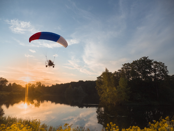 Ekstrem sporlar. Akşamları mavi gökyüzüne karşı paraşütle atlamak - Fotoğraf, Görsel