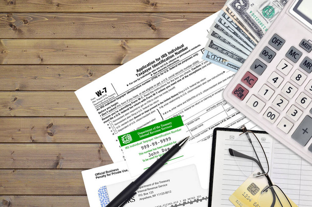 Formulario W-7 del IRS La solicitud para el número de identificación del contribuyente individual del IRS se encuentra en la mesa de oficina fija y lista para llenar. U.S. Concepto de papeleo de servicios de ingresos internos. ITIN
 - Foto, imagen