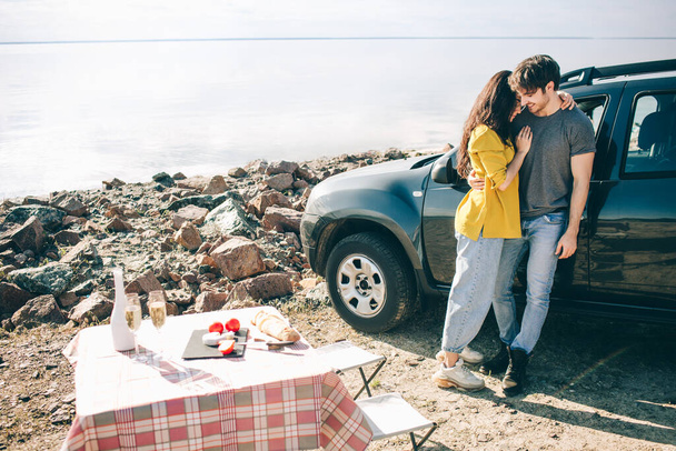 Picnic near the water. Happy family on a road trip in their car. Man and woman are traveling by the sea or the ocean or the river. Summer ride by automobile. - Photo, Image