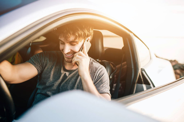 車で旅行する傾向のある若い男性。夏のロードトリップ旅行休暇でリラックスした幸せな男 - 写真・画像