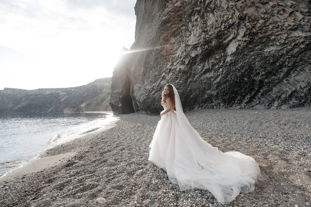 bride by sea. waves and mountains background. wedding on shore - Fotografie, Obrázek