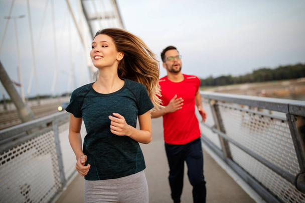 Beautiful couple jogging in nature living healthy - 写真・画像