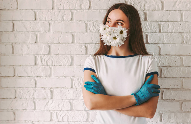 Portrait happy female doctor in summer medical face mask look at copy space and keep arms crossed. Young woman wearing protective face mask and medical gloves for COVID-19 protection. Spring allergy - Zdjęcie, obraz
