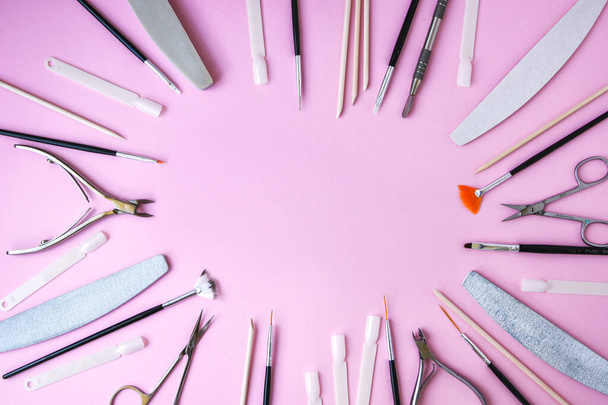 Manicure and pedicure tools on pink background, view from above. Nail salon banner design template. Beauty treatment concept. Copy space for text - Photo, Image