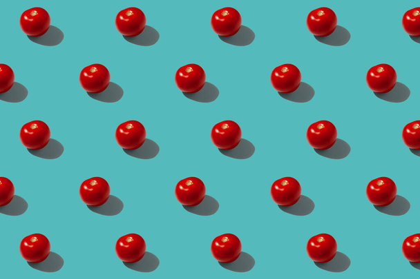 Red tomatoes on a turquoise background pattern - 写真・画像