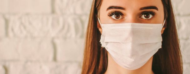 Banner confident female doctor surgeon in protective mask on face in hospital. Young sick woman in medical face mask. Infected girl wears face mask. Coronavirus COVID-19 protection. Personal safety - Фото, изображение