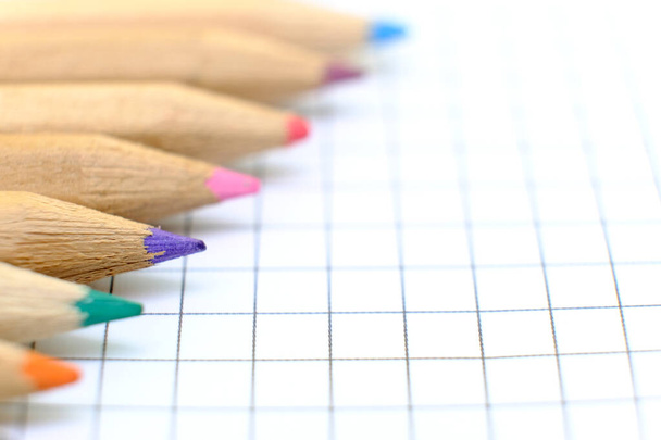 Zbliżenie zestaw kolorowych ołówków na kartce papieru z notatnikiem do rysunku. Wracając do koncepcji szkoły. Odbiór, żadnych ludzi. Płytka głębia ostrości - Zdjęcie, obraz