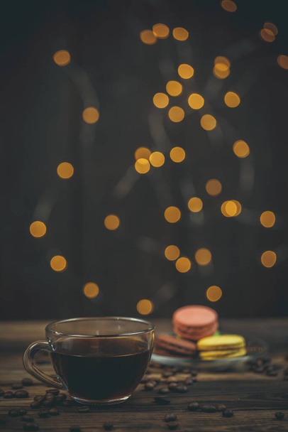 Tasty macaroon cookies with coffee on a wooden table in warm color with beautiful bokeh - Valokuva, kuva