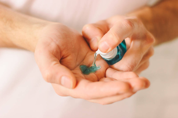 Closeup of man hands using antibacterial gel as preventive measure against contagious disease. Doctor applying sanitizer on palm for protection against coronavirus COVID-19, nCov-19. Safety hygiene - Foto, afbeelding