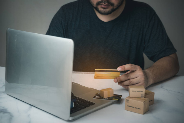 Hombre usando tarjeta de crédito amarilla para compras de pago en línea. Compras en línea en casa concepto
 - Foto, imagen