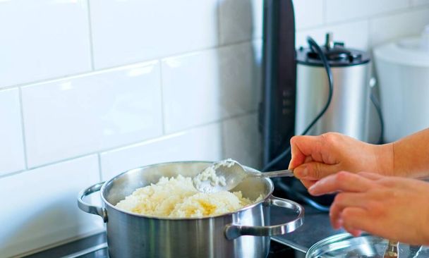 Close shot of hands cooking in a kitchen taking a spoon - Photo, image
