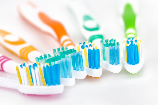 Punainen, keltainen, sininen ja vihreä hammasharjat. Hampaista huolehtiminen, hammashoito. Tasainen lay kuva, kopioi tilaa, ylhäältä - Valokuva, kuva