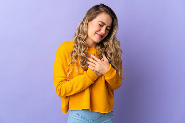 Young Brazilian woman isolated on purple background having a pain in the heart - Foto, Bild