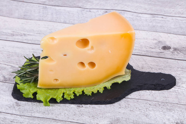 Maasdam sýr na desce podávané salátové listy a rozmarýn - Fotografie, Obrázek