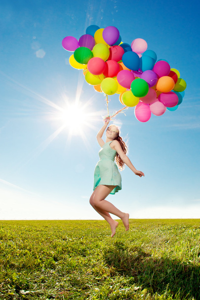 Luxury fashion woman with balloons in hand on the field against - Photo, Image