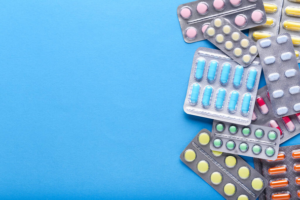 Colorful pills in blisters on blue background - Foto, Bild
