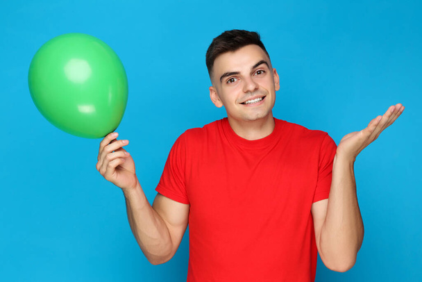 Yuong man with balloon on blue background - Fotografie, Obrázek