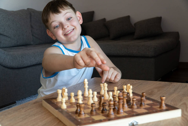 Cheerful child plays chess. A fun game with children in chess - 写真・画像