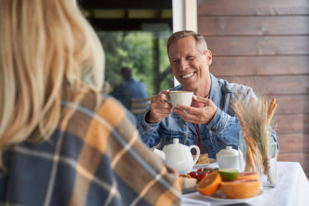 Happy aged man enjoying tea with beloved wife - Foto, Bild