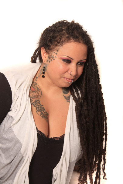 Mujer tatuada con piercings y rastas
 - Foto, imagen