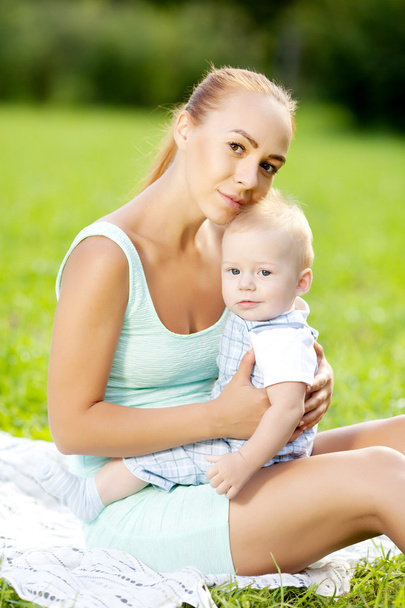 Lindo bebé en el parque de verano con la madre en la hierba. Swee.
 - Foto, Imagen