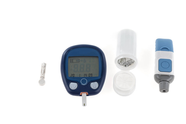 Diabetes glukoosipitoisuus verikoe käyttäen ultra mini glukometri pakki ja pieni pisara verta sormesta ja testi nauhat eristetty valkoisella pohjalla.  - Valokuva, kuva