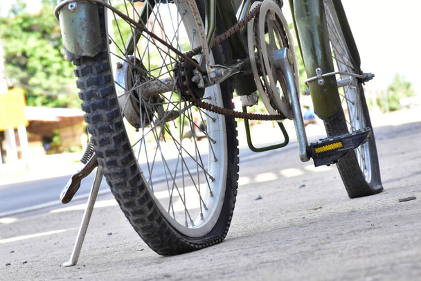 Closeup άποψη του ποδηλάτου επίπεδη ελαστικών στο πεζοδρόμιο. - Φωτογραφία, εικόνα