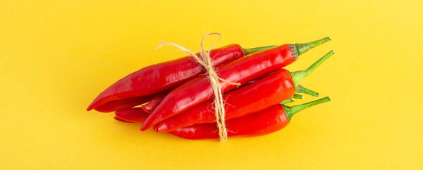 Red hot chili pepper on a yellow background.  - 写真・画像