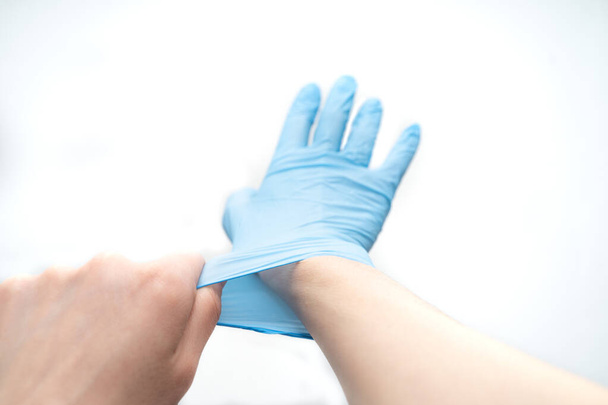 putting on a disposable latex glove on a white background - Photo, Image