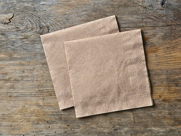 brown paper napkins on rustic wooden table, top view - Photo, Image