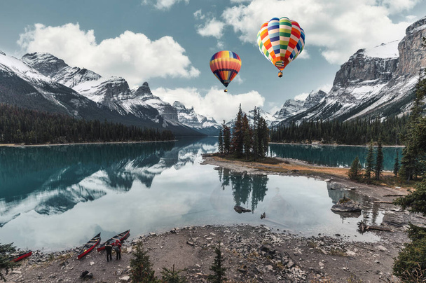 Landschaft von Spirit Island mit einem Heißluftballon, der im Maligne Lake im Jasper Nationalpark, AB, Kanada, fliegt - Foto, Bild