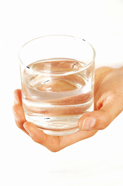 Female hand holding a glass with water on white background - Photo, Image