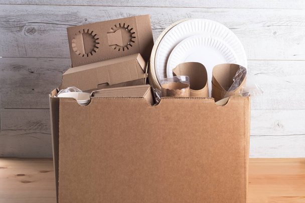 Platos de cocina ecológica, tazas, cajas y otros productos de cartón en la caja
. - Foto, imagen