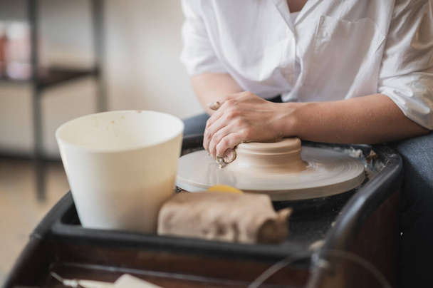 Zamknij nierozpoznawalny ceramik tworzących ręcznie wazon gliny przy użyciu specjalnego narzędzia i koła garncarskiego. - Zdjęcie, obraz
