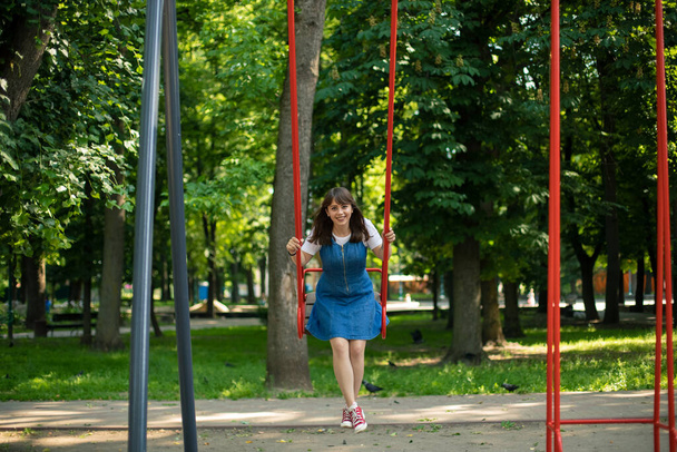 чарівний портрет дівчини-підлітка в розмахуванні дітей ігровий простір в літньому парку часу на відкритому повітрі посміхаючись і щасливі емоції концепції
 - Фото, зображення