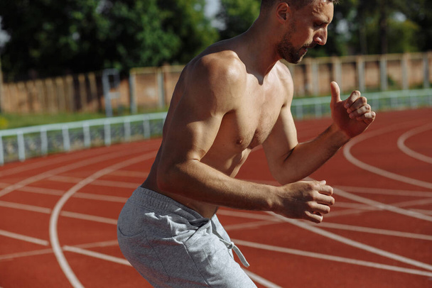 Hombre musculoso en topless calentándose antes del entrenamiento afuera. Deportista. Hombre fuerte
 - Foto, Imagen