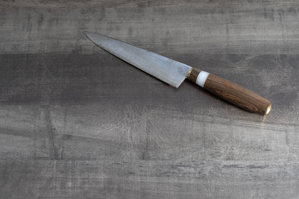 vintage kitchen knife with a wooden handle on a wooden table from old boards, top view, close up - Photo, Image