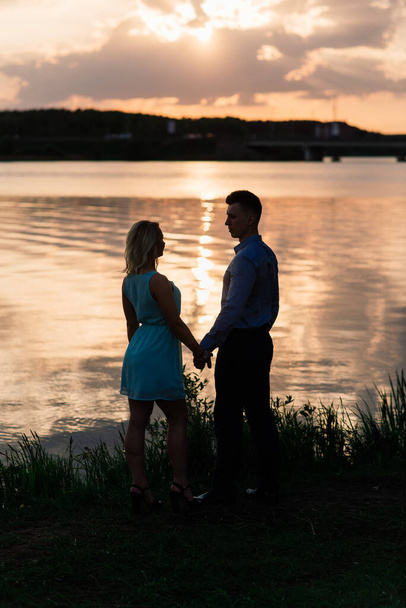Silouette, loving couple on the lake during sunset - Foto, Imagen